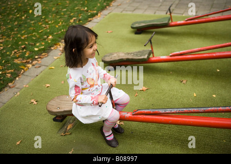 Circonscription d'une balançoire dans le terrain d'aventure au parc Victoria, Palmerston North, Nouvelle-Zélande. Jeune fille âgée de quatre ans Banque D'Images