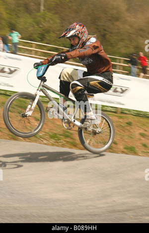 Jeune fille vélo BMX rider en compétition de sport de niveau national sauts sur une rampe de BMX Cheddar Somerset Angleterre cours Banque D'Images