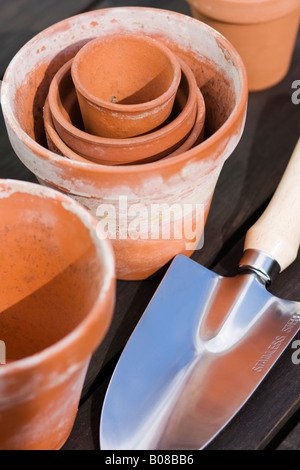 Pots de fleurs anciennes sur l'établi avec une truelle à encoches Banque D'Images