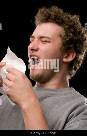 Jeune homme l'éternuement Banque D'Images