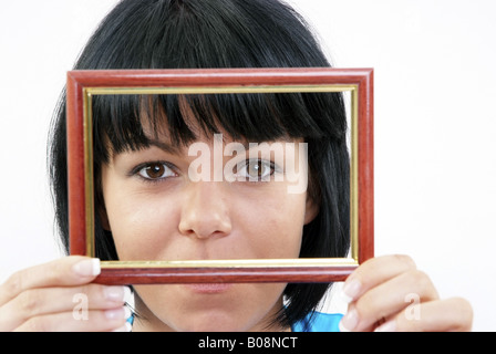 Les yeux d'une femme aux cheveux noirs dans un cadre photo Banque D'Images