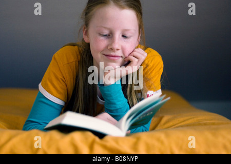 Girl lying down lire un livre Banque D'Images