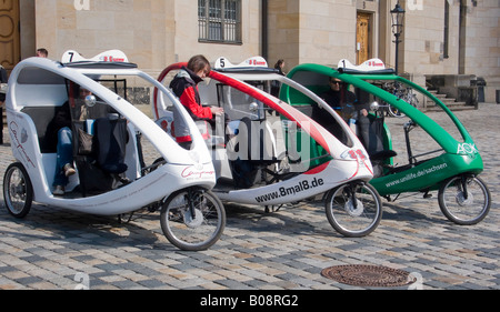 Location de vélo-taxi les taxis en stationnement sur une rue pavée de Dresde, Saxe, Allemagne Banque D'Images