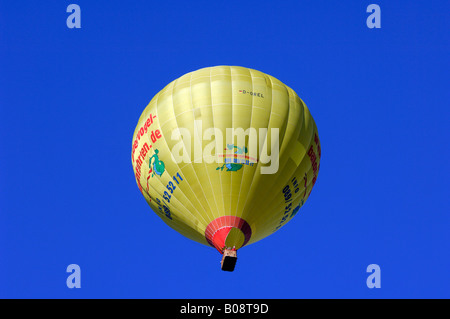 Ballon à air chaud jaune croissant dans un ciel bleu, Bad Wiessee, Upper Bavaria, Bavaria, Germany Banque D'Images
