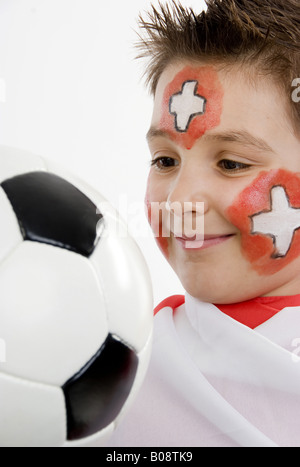 Garçon, rouged que Swiss fan de foot, avec le football dans sa main et d'un drapeau Banque D'Images