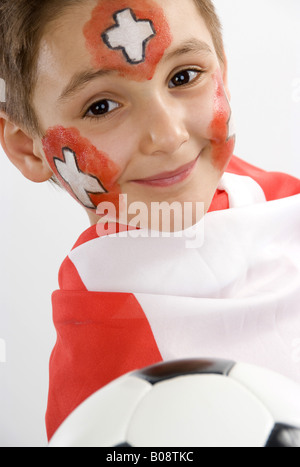 Garçon, rouged que Swiss fan de foot, avec le football dans sa main et d'un drapeau Banque D'Images