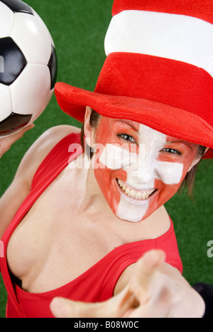 Cute woman in a Red top comme ventilateur Suisse, encourageant avec chapeau et le football Banque D'Images