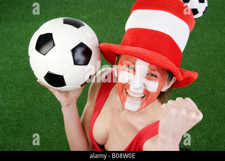 Cute woman in a Red top comme ventilateur Suisse, encourageant avec chapeau et le football Banque D'Images