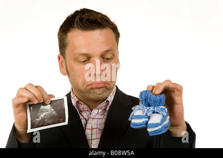 40-year-old woman holding baby shoes et une échographie photo à sceptique Banque D'Images