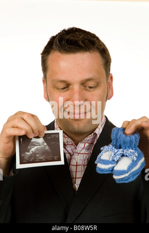 40-year-old woman holding baby shoes et une échographie photo Banque D'Images