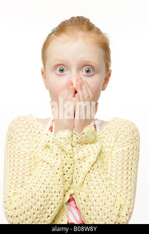 Rousse de 8 ans portant un chandail en tricot jaune, cavalier, à choqué Banque D'Images