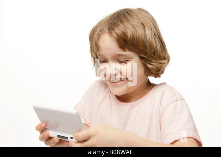 8-year-old girl playing Game Boy Banque D'Images