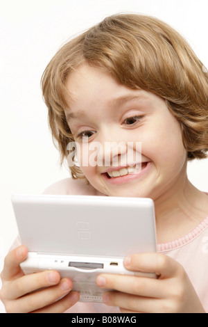 8-year-old girl playing Game Boy Banque D'Images