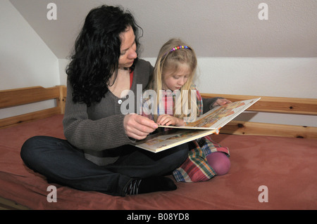 Une mère de famille, 10 ans, lire un livre Banque D'Images