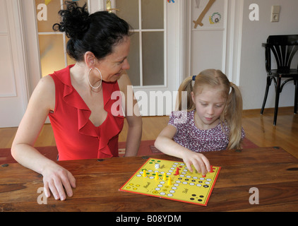 Une mère de famille, 10 ans, JOUER Ludo jeu Banque D'Images