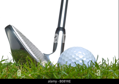 Close up d'une balle de golf allongé dans l'herbe avec un club de fer alignés pour un gazon Studio shot shot Banque D'Images