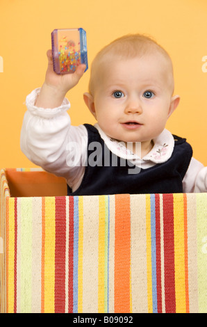 Bébé avec hochet dans une boîte Banque D'Images