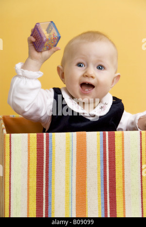 Bébé avec hochet dans une boîte Banque D'Images