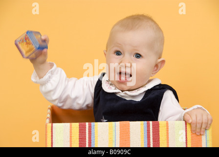 Bébé avec hochet dans une boîte Banque D'Images