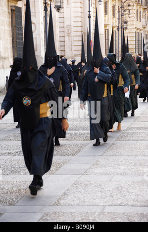 Pénitents vêtus de noir robes de pénitence (nazareno) sur leur façon de la Semana Santa, la Semaine Sainte Procession, Huelva, Andalousie Banque D'Images