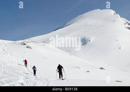 Skis de Randonnée traversant les alpinistes sur une pente enneigée menant à une montagne couverte de neige lacée avec pistes de ski, Ran Rofan Banque D'Images