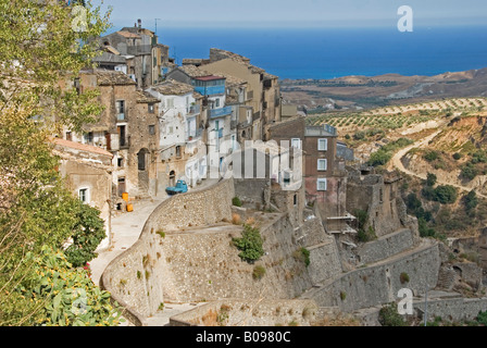 Mountain village construit sur des terrasses escarpées, vue sur la mer et les vergers à l'arrière, Povalino, Calabre, Italie Banque D'Images