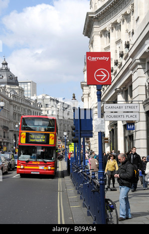 A deux étages, nous et les piétons sur le trottoir dans la scène de Regent Street à West End Londres avec des panneaux pour Carnaby Street et Fouberts place England Banque D'Images