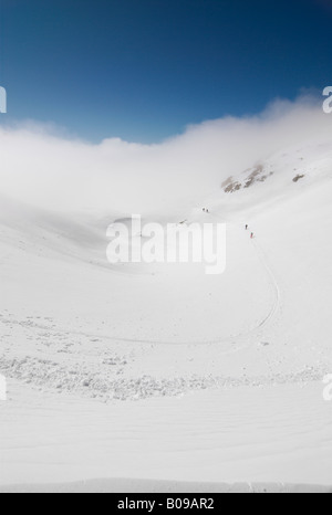 Groupe de skieurs près de Col Cicle sur une journée d'hiver ensoleillée au-dessus des nuages, Les Contamines-Montjoie, France Banque D'Images