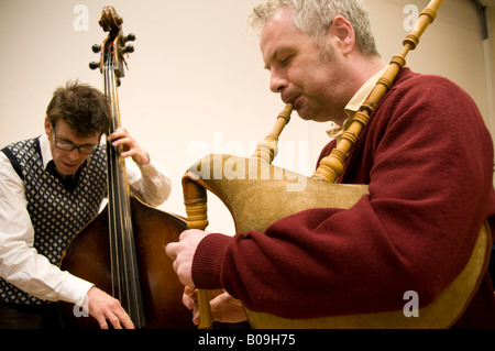 Homme jouant bagpies et un autre sur la verticale de la basse dans la musique folk jazz concert concert fusion Banque D'Images