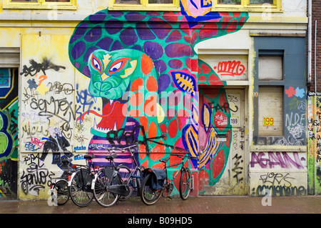 Amsterdam, dragon peint sur des murs sur un squat bar appelé le Spui dans Vrankrijk straat rue, des vélos en stationnement Banque D'Images