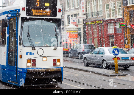 Amsterdam Nieuwezijds Voorburgwal, chute de neige dans la rue, le tram, bars Banque D'Images