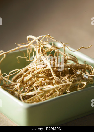 Les racines de ginseng dans un bol vert Banque D'Images