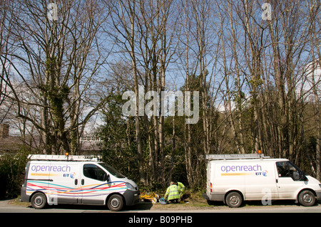 Deux BT openreach cars avec les ingénieurs de téléphone entre en s'agenouillant sur le terrain travaillant sur les lignes téléphoniques Banque D'Images