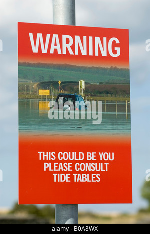 Les conducteurs d'avertissement d'un signe sur les dangers de la chaussée à marée Beal Lindisfarne, Holy Island, Banque D'Images