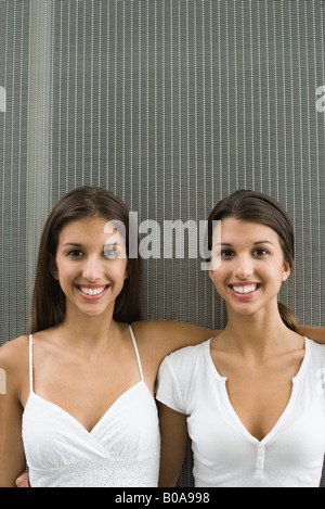 Teenage Twin Sisters avec les bras l'un autour de l'autre, portrait Banque D'Images