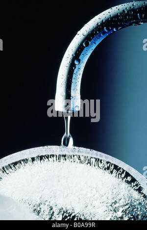 Robinet de l'eau dégoulinant sur la glace, close-up Banque D'Images