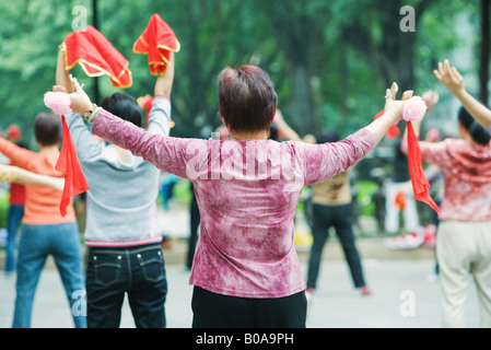 La Chine, Guangzhou, les femmes pratiquant le tai chi chuan à l'extérieur, vue arrière Banque D'Images