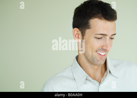 Man smiling, regardant vers le bas, la tête et épaules, portrait Banque D'Images