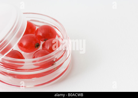 Groseilles rouges dans de petits contenants cosmétiques Banque D'Images