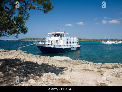 Le plaisir "Jumbo" bateau amarré dans la mer cristalline à Arenal de fils Saura, Menorca, Ballearic, Espagne. Banque D'Images