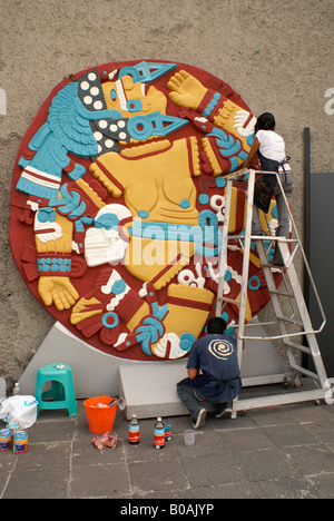 Peintres sur réplica de pierre montrant déesse Coyolxauhqui démembrée, Museo del Templo Mayor, Mexico Banque D'Images