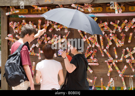 Les touristes à côté de vœux sur une Wishing Tree à Hong Kong, Chine Banque D'Images