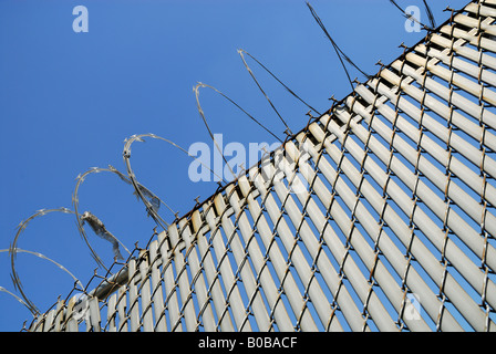 Clôture avec barbelés contre le ciel bleu Banque D'Images