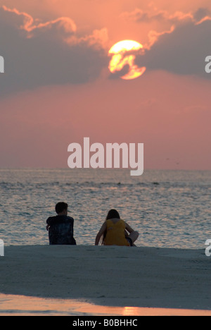 Couple en regardant le coucher de soleil sur la plage tropicale de sable Island Maldives Kuramathi Banque D'Images
