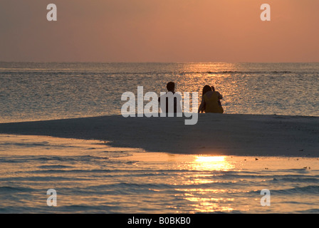 Couple en regardant le coucher de soleil sur la plage tropicale de sable Island Maldives Kuramathi Banque D'Images