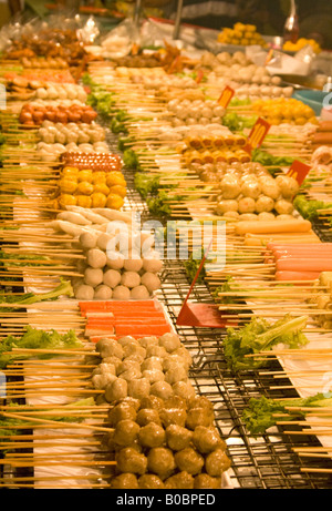 Lignes de différents aliments sur des bâtons prêts pour la cuisson au barbecue at a market stall Banque D'Images