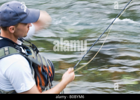 Un homme d'action de pêche de mouche avec blur. Banque D'Images