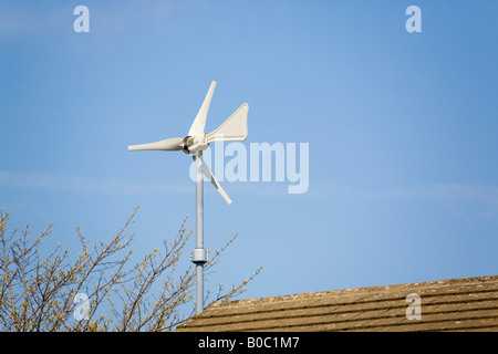 Wndsave micro wind turbine montée sur le mur de la maison au-dessus de toit contre ciel bleu Windsave 1200 se connecte au réseau national de la queue de la lame Banque D'Images