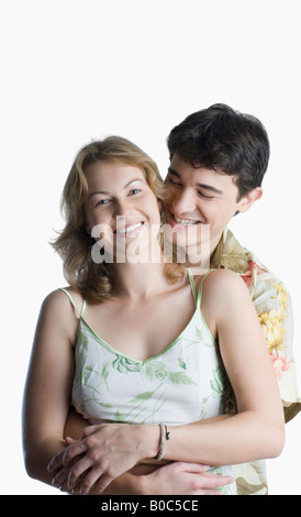 Jeune homme embrassant une jeune femme par derrière et smiling Banque D'Images