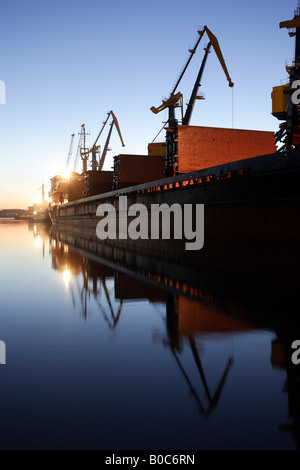 Grues de rechargement dans un port dans la soirée, Wismar, Allemagne Banque D'Images
